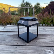 Solcellsdriven lykta Solar Square på en altan i en trädgård