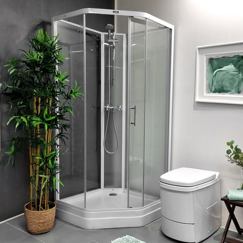 Modernt badrum med duschkabin Elsa vit i glas, vit El-dorado förbränningstoalett, handdukstork och gröna växter som inredningsdetaljer